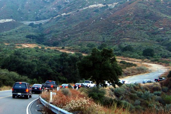 Cars winding along Ortega Highway above the canyon